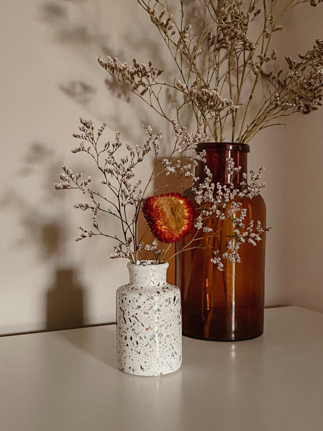 Red flowers in a white ceramic vase