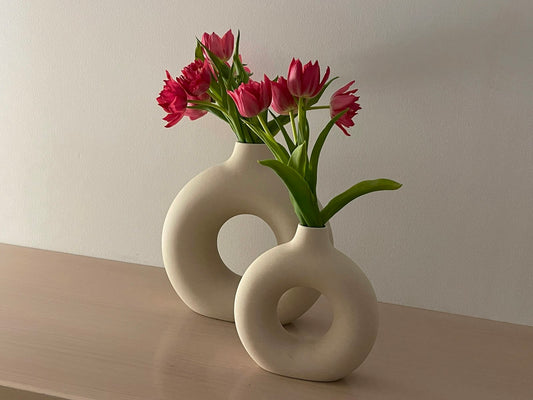 White vase with pink flowers in a small space